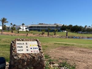 un panneau dans un champ avec un bâtiment en arrière-plan dans l'établissement Pickalbatros Golf Luxury Suites - All Inclusive, à Charm el-Cheikh 239 autres photos