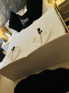 a bed with two roses on top of it at Couple's Getaway in Is-Swieqi