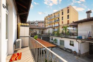an apartment balcony with a wooden table and buildings at BGY Airport 10Min Casa Moderna con Ampio Balcone in Bergamo