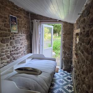 a bedroom with a bed in a room with a window at Chambre entre terre et mer in Le Gouray