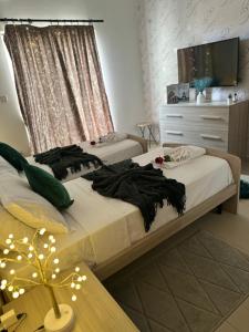 a bedroom with two beds and a dresser at Couple's Getaway in Is-Swieqi