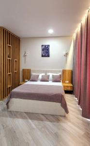 a bedroom with a large bed and red curtains at Bamboo Beach Tsikhisdziri 347K in Tsikhisdziri