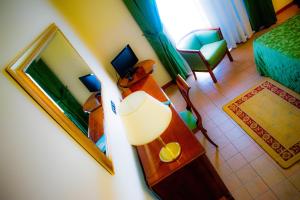 a room with a bed and a table and a mirror at Hotel Villa Peretti in Gela