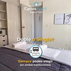 Un dormitorio con una cama con dos toallas encima. en CyclosApart Bariloche, en San Carlos de Bariloche