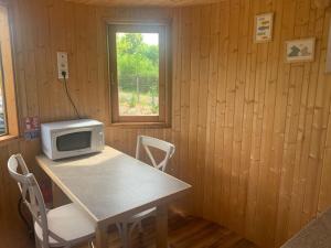 TV a/nebo společenská místnost v ubytování La Feuille - Cabane isolée avec vue sur étang, terrasse privée & pêche