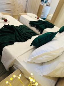 two beds with green and white sheets and pillows at Couple's Getaway in Is-Swieqi