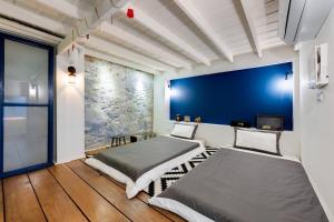 twee bedden in een kamer met een blauwe muur bij Non Inn The Barber King and Twin Rooms with Vintage Charm and Unique Design near Riverside and ICONSIAM in Bang Rak