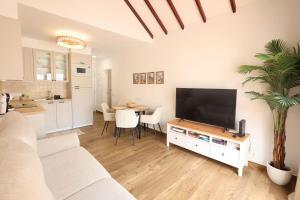 un salon avec une télévision et une table avec des chaises dans l'établissement Apartamento Sebastian, à Adeje
