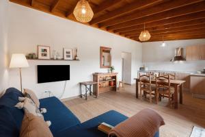 a living room with a blue couch and a kitchen at Complejo Rural Pajar de Bento in Agulo