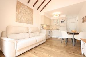 un salon avec un canapé blanc et une table dans l'établissement Apartamento Sebastian, à Adeje 2 autres photos