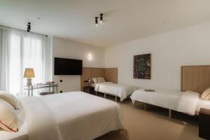 En eller flere senge i et værelse på Design Suites by Olala Homes