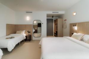 En eller flere senge i et værelse på Design Suites by Olala Homes