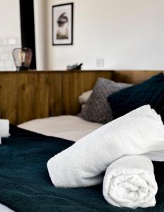 ein Stapel Handtücher auf einem Bett in der Unterkunft Lakeside Eco Lodge- 'Heron' in Bishampton