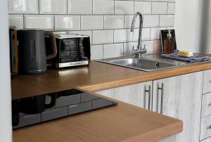 eine Küchentheke mit Spüle und Mikrowelle in der Unterkunft Lakeside Eco Lodge- 'Heron' in Bishampton