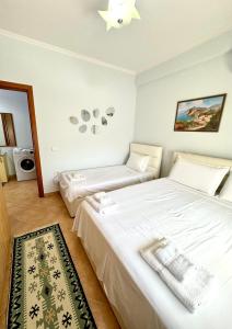 a bedroom with two beds with white sheets at Four Seasons Beach Apartment Golem in Golem