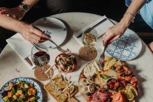 a table with plates of food and glasses of wine at Velamar Boutique Hotel - Adults Friendly in Albufeira