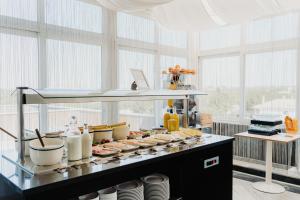 a buffet line with food on a counter with windows at Velamar Boutique Hotel - Adults Friendly in Albufeira