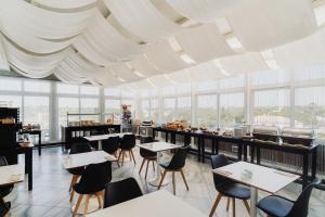 a restaurant with tables and chairs and windows at Velamar Boutique Hotel - Adults Friendly in Albufeira