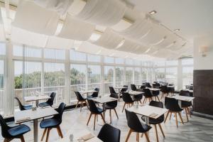 a dining room with tables and chairs and large windows at Velamar Boutique Hotel - Adults Friendly in Albufeira +31 photos