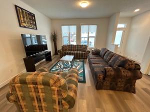 a living room with couches and a couch and a table at Seton Villas Cozy Four-bed house in Calgary