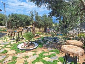 a garden with two stools and a table and benches at Harmony Blue Pansiyon in Burhaniye