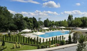 a pool with chairs and umbrellas in a garden at Hill Chalet Hotel Gabala in Gabala