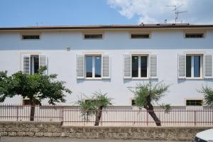 a white house with white windows and a fence at La Lenzerina in Scarlino