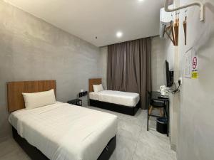 a hotel room with two beds and a desk at HPY Hotel in Ipoh