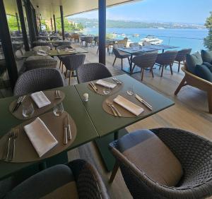 a restaurant with tables and chairs with a view of the water at Amadria Park Grand Hotel 4 Opatijska Cvijeta in Opatija