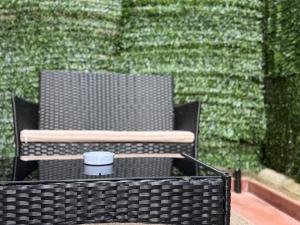 a black wicker chair sitting in front of a green wall at Casa Teresa Guest Rooms in Parghelia