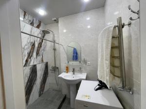 une salle de bain blanche avec un lavabo et des toilettes dans l'établissement Home comfort near Samarkand airport, à Samarcande