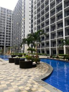 a swimming pool in front of a large building at Obetskie's Haven Condotel in Manila