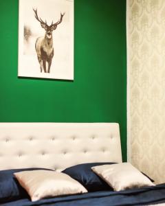 a green bedroom with a bed with a deer picture on the wall at Forest Central Sarajevo in Sarajevo