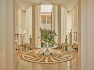 a lobby with a large clock in the middle of a room at Rocco Forte The Charles Hotel in Munich