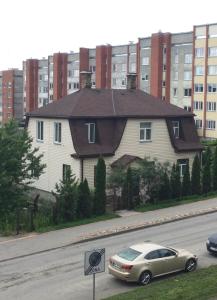 una casa con un'auto parcheggiata sul lato di una strada di AV ApartmenT a Rēzekne