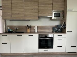 a kitchen with white cabinets and a microwave at Ferienhaus Meerweh mit Sauna in Butjadingen