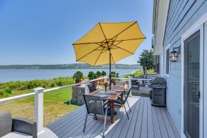 ポーツマスにあるCoastal Portsmouth Home with Bay Access Near Newportの木製デッキ(テーブル、傘付)