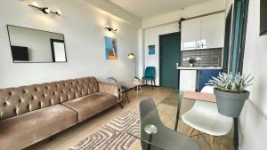 a living room with a couch and a kitchen at Sea Romantic Apartment in Gonio