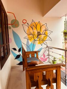 ein Wandbild einer gelben Blume an einer Wand in der Unterkunft Mud apples varkalaa in Varkala