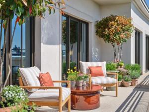 a patio with chairs and a table and plants at Rocco Forte The Charles Hotel in Munich