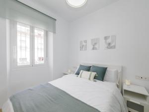 ein weißes Schlafzimmer mit einem Bett und zwei Fenstern in der Unterkunft Cubo's Lola Nueva House Town Center in Alhaurín el Grande