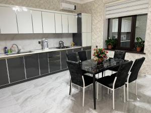 a kitchen with a black table and chairs and a sink at Relax Gabala in Gabala +5 photos