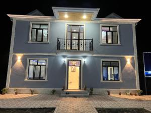 a large blue house with a yellow door at Relax Gabala in Gabala