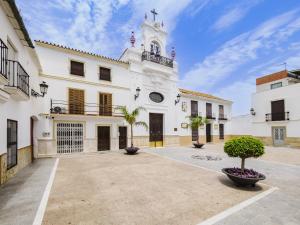 ein großes weißes Gebäude mit einem Uhrenturm in der Unterkunft Cubo's Lola Nueva House Town Center in Alhaurín el Grande