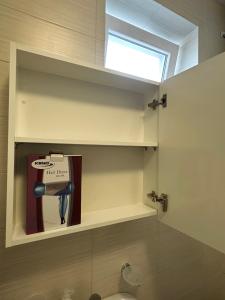 a bathroom with a shelf with a book and a window at Seas the Day Studio in Herceg-Novi