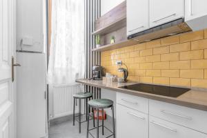 a kitchen with a counter with stools and a sink at Central Six in Oradea