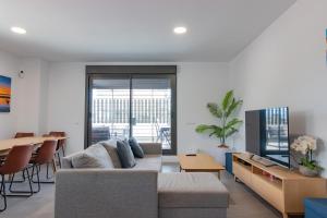 Televízia a/alebo spoločenská miestnosť v ubytovaní Beachfront Apartment 034