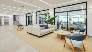 a living room with a couch and a table and chairs at Sercotel Cruz Del Mar in Chipiona