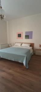a bedroom with a bed with paintings on the wall at Esperia Maison B&b in Montesarchio