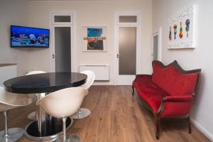 a living room with a red couch and a table at Esperia Maison B&b in Montesarchio